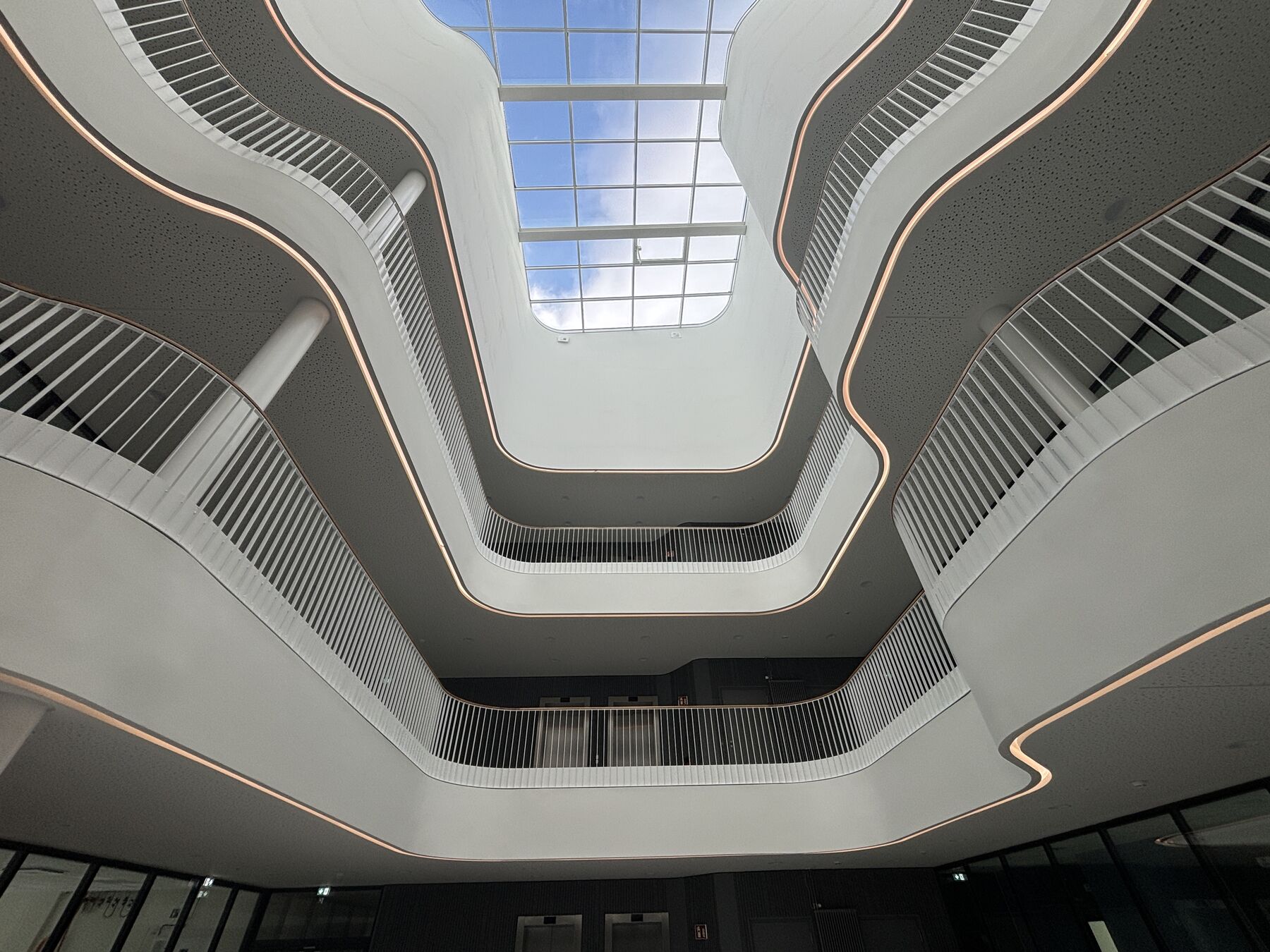 Lichtdurchflutetes Atrium des Laborneubaus mit geschwungenen Galerien und großem Oberlicht