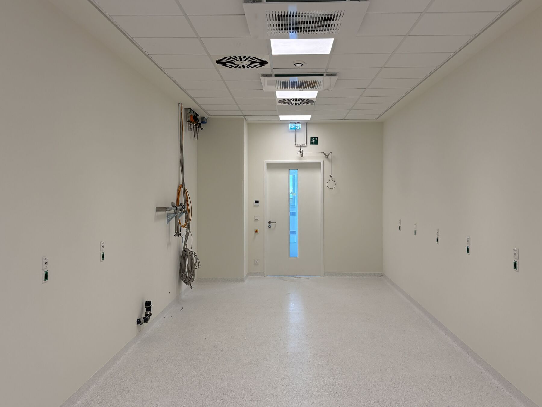 Offene Bürofläche mit höhenverstellbaren Schreibtischen und Verglasung zum Atrium